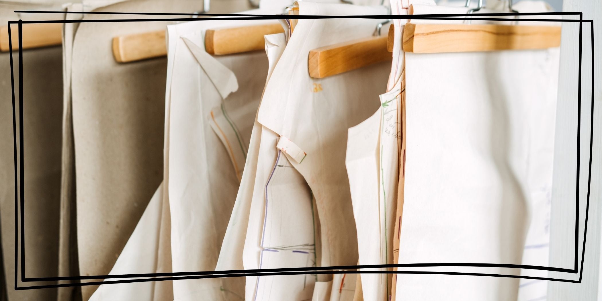 A row of paper patterns hanging on wooden hangers