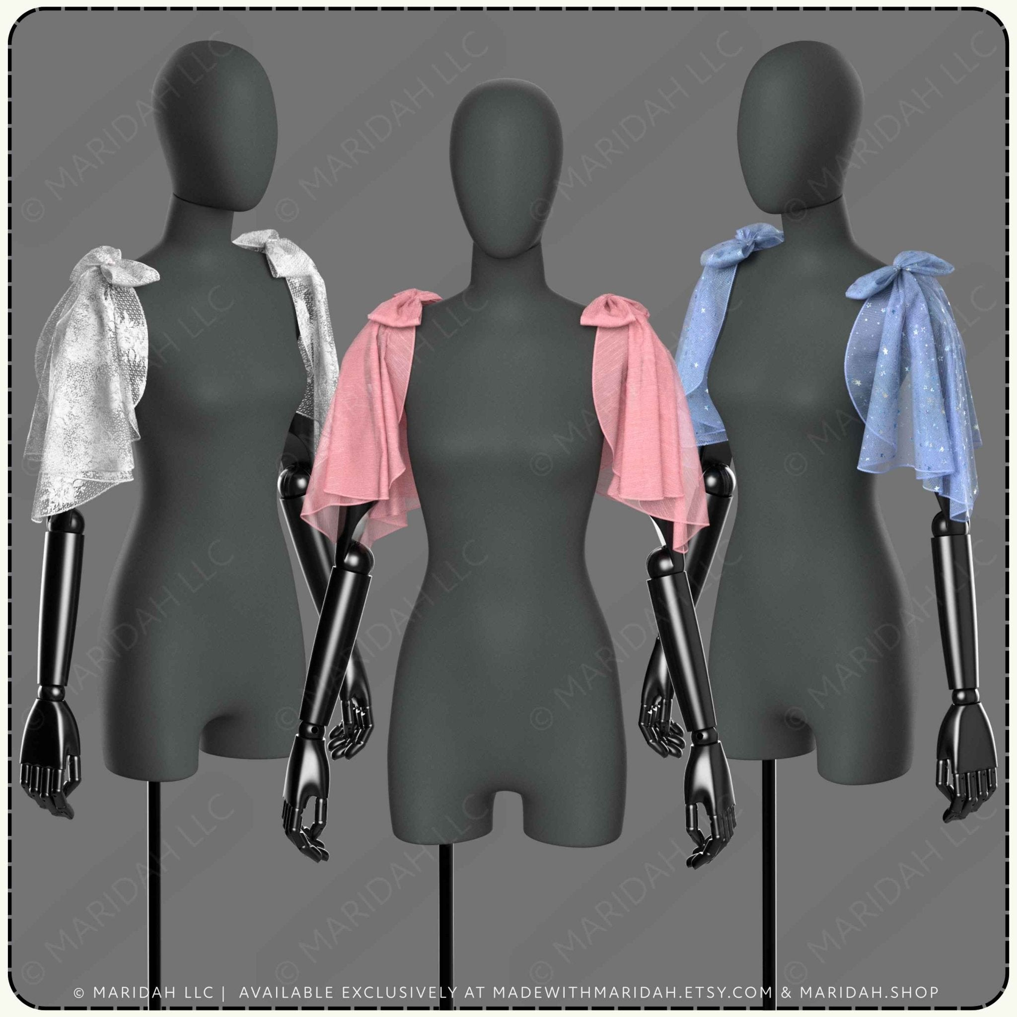 Three black dress forms/mannequins display draped satin shawls in silver, pink, and light blue against a gray background.